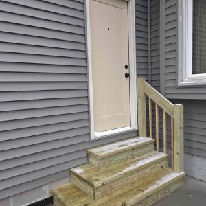New home addition in Brookfield, WI featuring gray horizontal siding and professional window installation by Elite Home Renovations.
