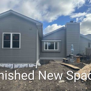 New exterior entryway with custom wooden stairs and matching siding for a Brookfield home addition project.