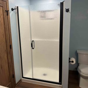 Modern bathroom addition featuring a glass-door walk-in shower, luxury flooring, and contemporary vanity area.