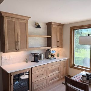 Custom kitchen coffee bar with floating wood shelves, under-shelf lighting, light countertops, and built-in beverage cooler.   